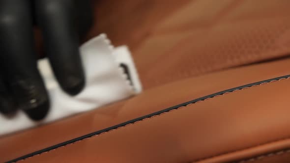 Waxing with a White Sponge on a Leather Car Seat Closeup