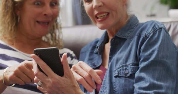 Animation of happy diverse female senior friends using smartphone alt