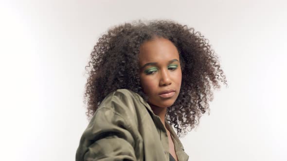Young Mixed Race Model in Studio on White with Curly Hair, Bright Green Eye Makeup
