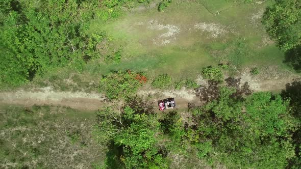 Aerial view two quadricycles doing trail next Chocolate Hills Complex, Batuan. alt