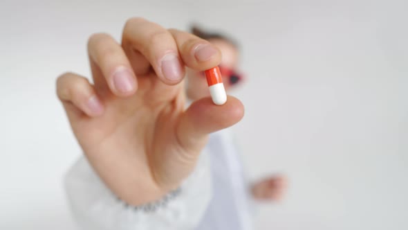 A Close View of Woman Hand Holding Whiteorange Capsule of Health