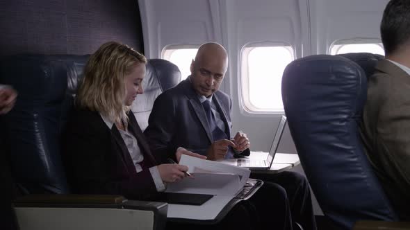 Business people working on airplane flight