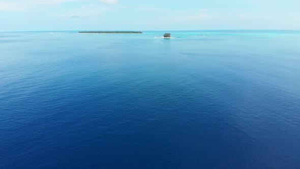 Aerial: flying over desert island tropical beach caribbean sea coral reef sunset alt