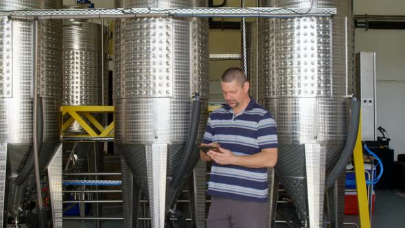 Male worker using digital tablet in distillery 4k alt