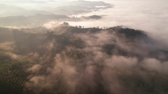 4K aerial view over a misty mountainous area. The great golden sun in the morning alt