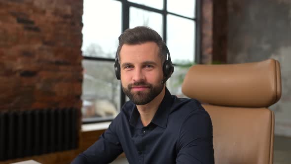 Positive Young Handsome Bearded Man Employee in Headset