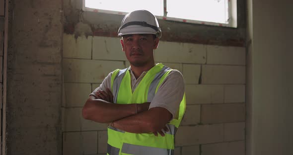 Industrial Engineer Man In Hard Hat Wearing Safety Jacket Working In The Building Construction Site. alt
