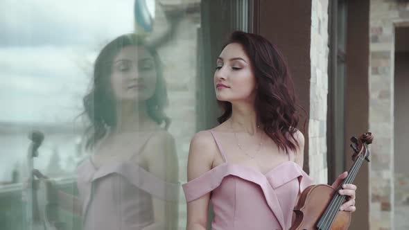 Elegant Woman Enthusiastically Playing on the Violin at Building alt
