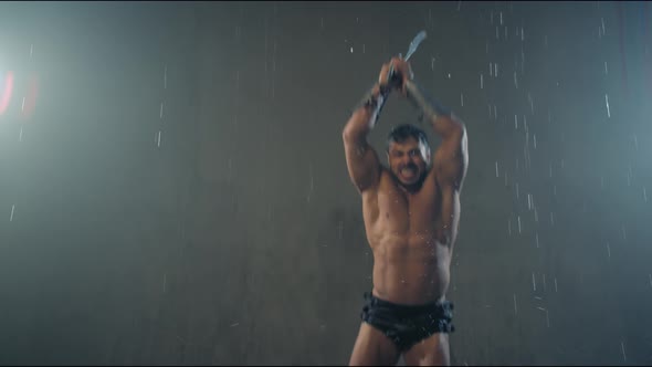 Shirtless Gladiator Jumping in Attack Under Rain. alt