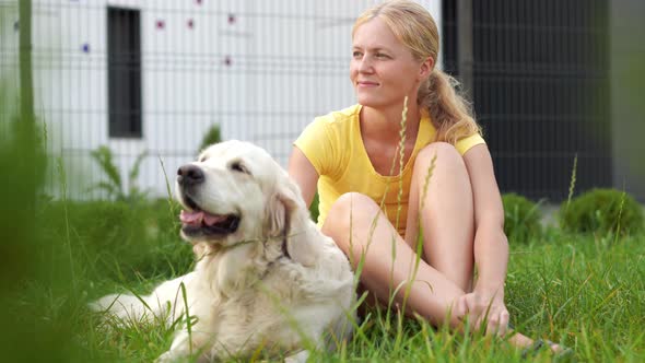 Love for Pets - a Young Blonde Woman Resting with Her Dog on the Grass