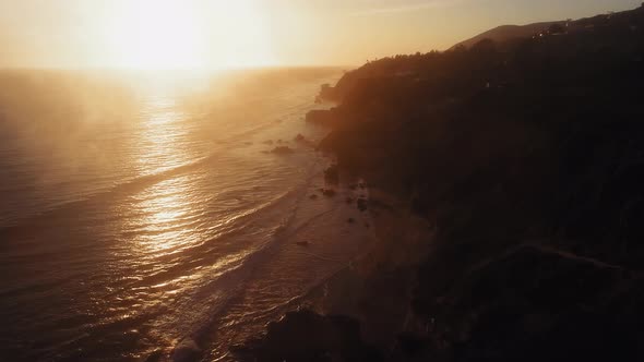Drone view of path on the ocean surface and dusky shore at El Matador Beach, Malibu, Califronia, USA alt