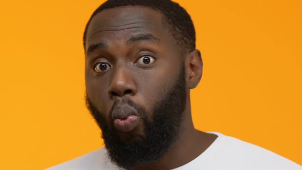 Surprised African Man Eating Popcorn on Bright Background, Watching Tv ...