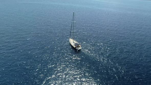 Aerial view of a sailboat driving forward in the mediterranean sea, Greece. alt