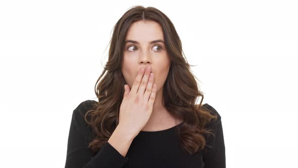 Surprised Caucasian Female with Burnette Long Hair Covering Mouth with Hand Standing on White alt