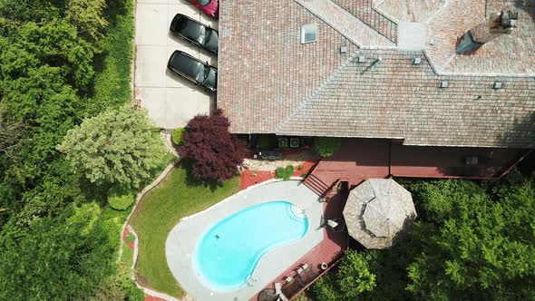 cinematic aerial view of a luxury residential house with personal swimming pool with 3 luxury cars 4 alt