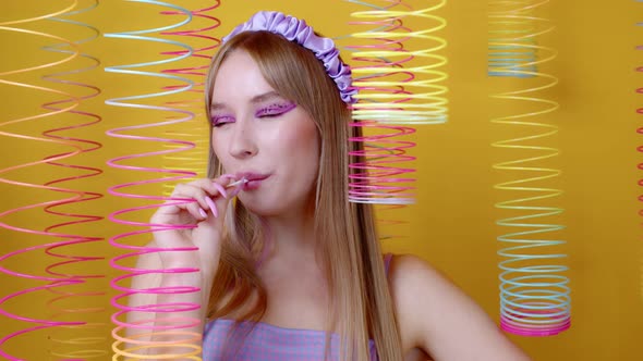 Sexy Girl Smiles Licks Round Caramel on Stick alt