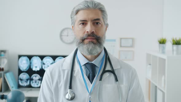 Slow Motion Portrait of Professional Doctor in White Gown Indoors in Workplace alt