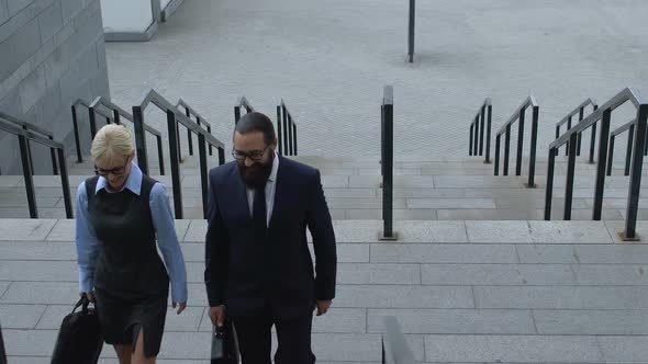 Lady and Male Partners Walking on Staircase Near Office Building, Cooperation