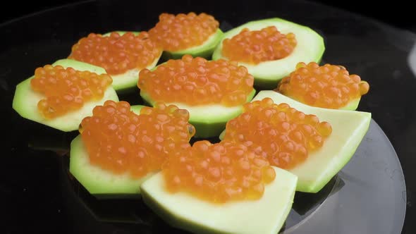 Red Caviar Is Put with a Spoon on Tartlets. Preparation of Snacks with Red Caviar. Top View alt
