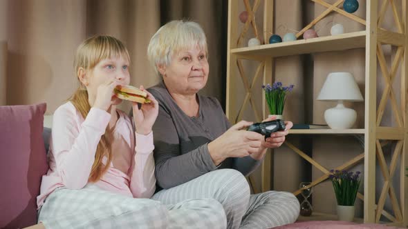 Rest with a Child  an Elderly Lady Plays Video Games with Her Granddaughter alt