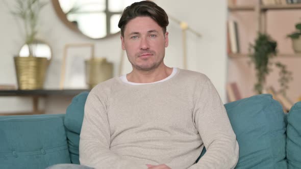 Serious Middle Aged Man Looking at the Camera at Home alt