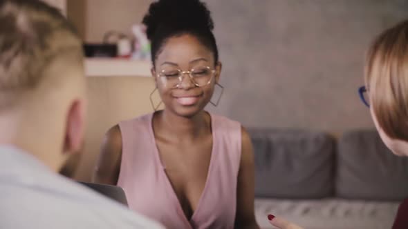 Beautiful African American Businesswoman Sits Down By the Table, Smiles at Multiethnic Colleagues at alt