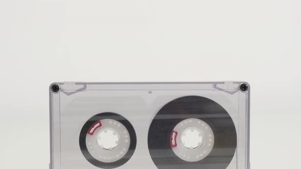 Transparent compact  audio cassette on white 4K 2160p 30fps UltraHD tilting footage - Retro  analogu
