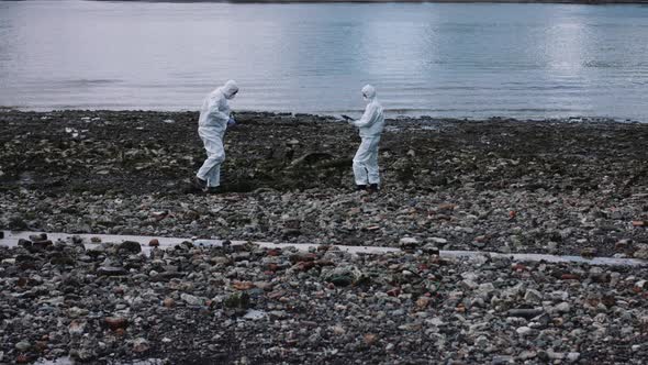 Forensic scientist examining sample at river bank