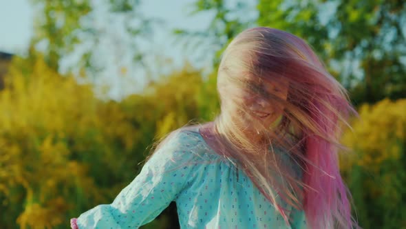 A Carefree Baby with Pink Hair Shakes His Head alt