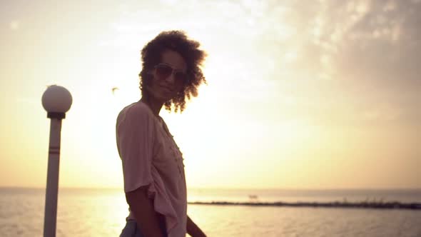 African American Young Girl with Curly Hair in Sunglasses Looking at Camera Smiling Standing in alt
