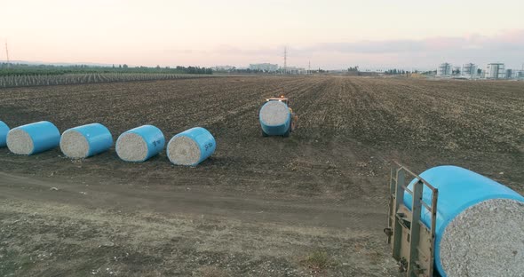 Aerial view of a tractor loading cotton bales on truck, Israel. alt