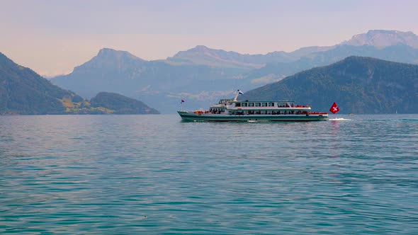 Cruise ship with tourists on the background of the Alpine mountains on Lake Lucerne in Switzerland. alt