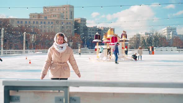 Young Smiling Woman Ice Skating Outside on Ice Rink Central City Square at Christmas Holiday Active alt