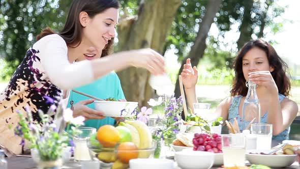 Friends eating healthy meal together outdoors