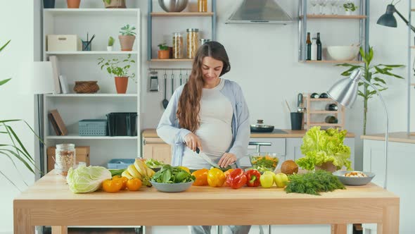 Beautiful Pregnant Woman Happily Preparing a Vegetable Salad The Concept Of Diet alt