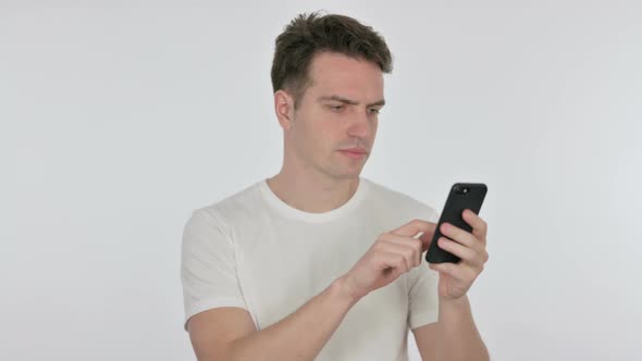 Young Man Celebrating on Smartphone on White Background alt