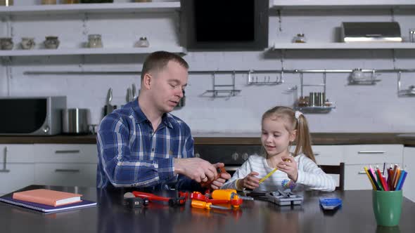 Dad Showing in Action To Little Girl Use of Wrench alt