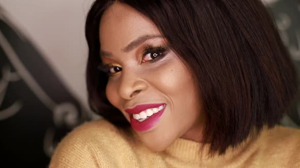 Beautiful young woman of African descent uses her smartphone. alt