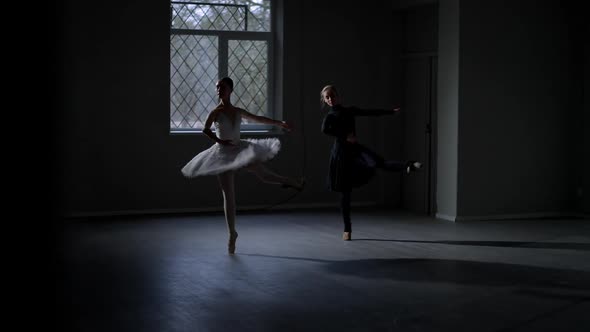 Wide Shot Two Slim Young Women Dancing Ballet in Darkness alt