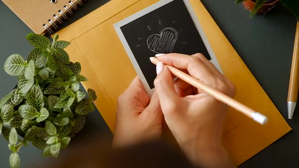 Closeup of the hand of a young girl with a beautiful manicure draw a heart