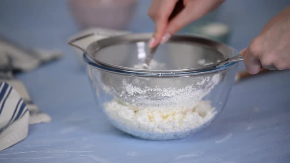 Rubbing cottage cheese through a sieve.	