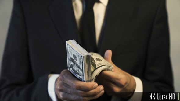 4K Businessman Holding and Counting American $100 Dollar Banknotes for Money and Financial Concept alt