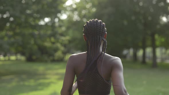 Back View of Woman with Afro Braids Jogging at City Park alt