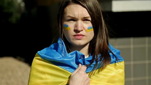 Portrait of a Woman with a Ukrainian Flag on His Shoulders