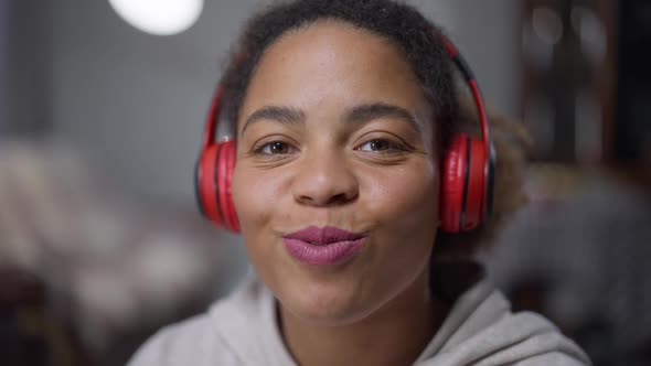 Headshot Portrait of Young Beautiful African American Woman Turning on Music in Headphones and alt