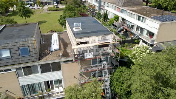 Jib up of rooftop under construction and renovation in a green suburban neighborhood alt