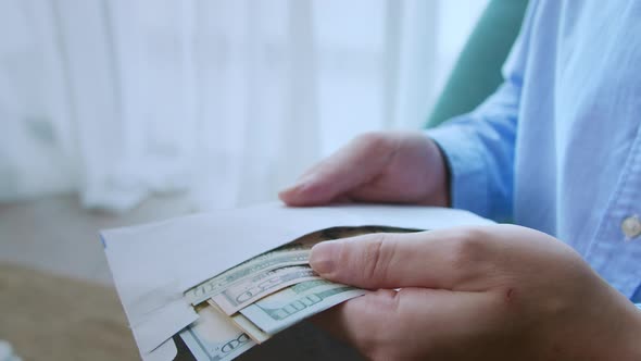 Man Gives 100 and 50 Dollar Bills From His Shirt Pocket Counts the Money Then Folds It in Half and alt