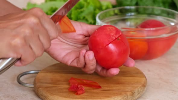 Peeling red tomatoes. Skin Removal process from tomato in glass bowl. Cooking vegetarian food