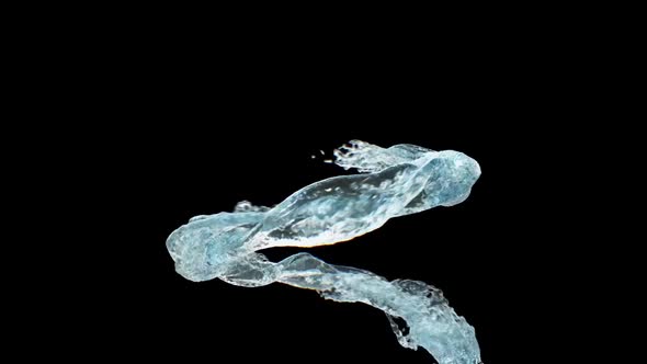 The Liquid Splashes And Twists Into A Spiral On A Black Background