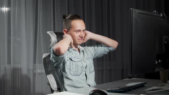 Happy Man Finishing Work on His Computer Late at Night alt